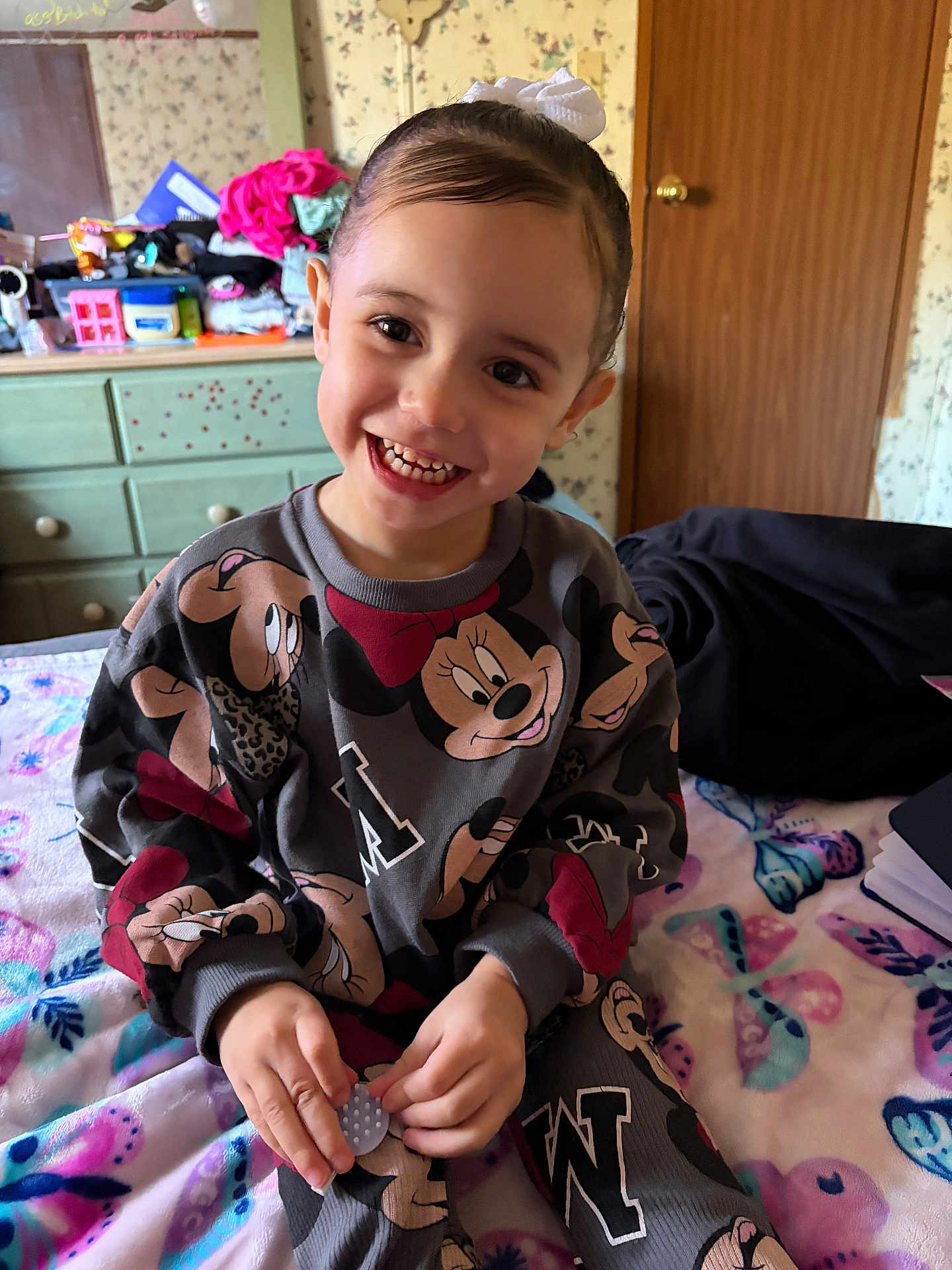 Nylah Bland joined the competition — help win amazing prizes! child, smiling, indoor, bed, blanket, clothing, dresser, door, furniture, person, happy, hand, face, toy, pattern, hair, room, sitting, cute, playful