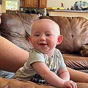 Avery joined the competition — help win amazing prizes! baby, smiling, couch, living_room, infant, happy, person, furniture, arm, face, skin, head, clothing, window, cabinet, home, interior, relaxing, casual, daylight