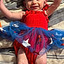 Avery joined the competition — help win amazing prizes! baby, smiling, red_outfit, blue_skirt, headband, bow, arms_up, blanket, striped_blanket, happy, cute, infant, tulle_skirt, stars, lying_down, indoors, person, child, skin, face