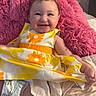 baby, child, smiling, portrait, indoor, sitting, pink_blanket, fluffy_cushion, floral_dress, yellow, orange, white, diaper, bed, home, happy, face, arms, legs, cozy