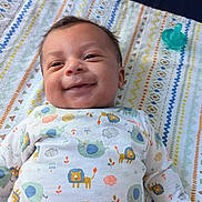 Sebastian joined the competition — help win amazing prizes! animal_print, baby, blanket, child, clothing, comfort, cute, face, happy, indoors, infant, lying_down, onesie, pacifier, pattern, person, portrait, sleepwear, smile, soft_toys