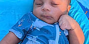 Sebastian is registered to the contest to win money with this photo: baby, infant, child, blue_clothing, cushion, seat, face, hand, sitting, expression, outdoor, sunlight, closeup, young_child, cute, portrait, skin, hair, relaxing, baby_clothes