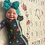 baby, smiling, headband, bow, onesie, floral_blanket, milestone_blanket, numbers, heart, lying_down, cute, child, infant, clothing, patterned_clothing, happy, face, portrait, indoors, soft_lighting