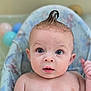 Christian is registered to the contest to win money with this photo: baby, child, face, blue_eyes, mohawk, wet_skin, baby_seat, pastel_colors, balls, curious_expression, indoor, portrait, infant, skin, head, eyes, mouth, hand, cushion, soft_light