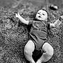 baby, infant, child, onesie, dinosaur, carpet, black_and_white, cute, chubby, lying_down, arms_outstretched, clothing, expression, indoor, texture, soft, portrait, humor, young, person