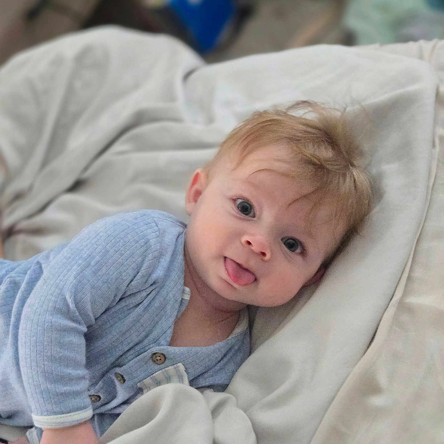 Christian joined the competition — help win amazing prizes! baby, bedroom, blanket, blue_clothing, child, comfort, cute, expression, face, hair, happy, indoor, infant, long_sleeves, lying_down, pale_skin, person, soft_texture, tongue_out, young_child