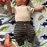 Bryer joined the competition — help win amazing prizes! baby, infant, hand, foot, striped_pants, dinosaur_slippers, blanket, dinosaur_pattern, person, sleepwear, cute, newborn, grasping, family, cozy, lying_down, soft_texture, colorful, indoor, casual