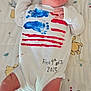 newborn, baby, sleeping, onesie, handprints, red_stripes, blue_paint, blanket, animal_pattern, tree_pattern, handwritten_text, infant, cute, peaceful, lying_down, indoors, soft_lighting, portrait, small_hands, clothing
