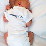 Christopher joined the competition — help win amazing prizes! newborn, baby, sleeping, white_onesie, infant, back_view, soft_lighting, white_background, peaceful, cute, tiny, human, child, bed, resting, skin, head, feet, clothing, portrait