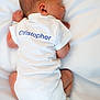 newborn, baby, sleeping, white_onesie, infant, back_view, soft_lighting, white_background, peaceful, cute, tiny, human, child, bed, resting, skin, head, feet, clothing, portrait
