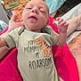 Christopher joined the competition — help win amazing prizes! baby, infant, onesie, dinosaur, clothing, hand, person, bed, blanket, colorful, pattern, floor, cute, sleepy, indoors, newborn, soft, skin, lying, cozy