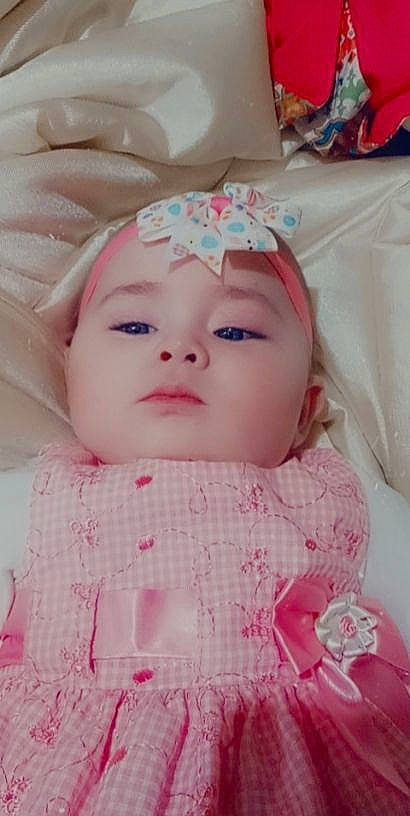 Skyla is registered to the contest to win money with this photo: baby, baby_toddler_clothing, cap, cheek, chin, dress, eye, eyebrow, eyelash, face, head, headgear, headwear, iris, lip, magenta, person, pink, product, skin