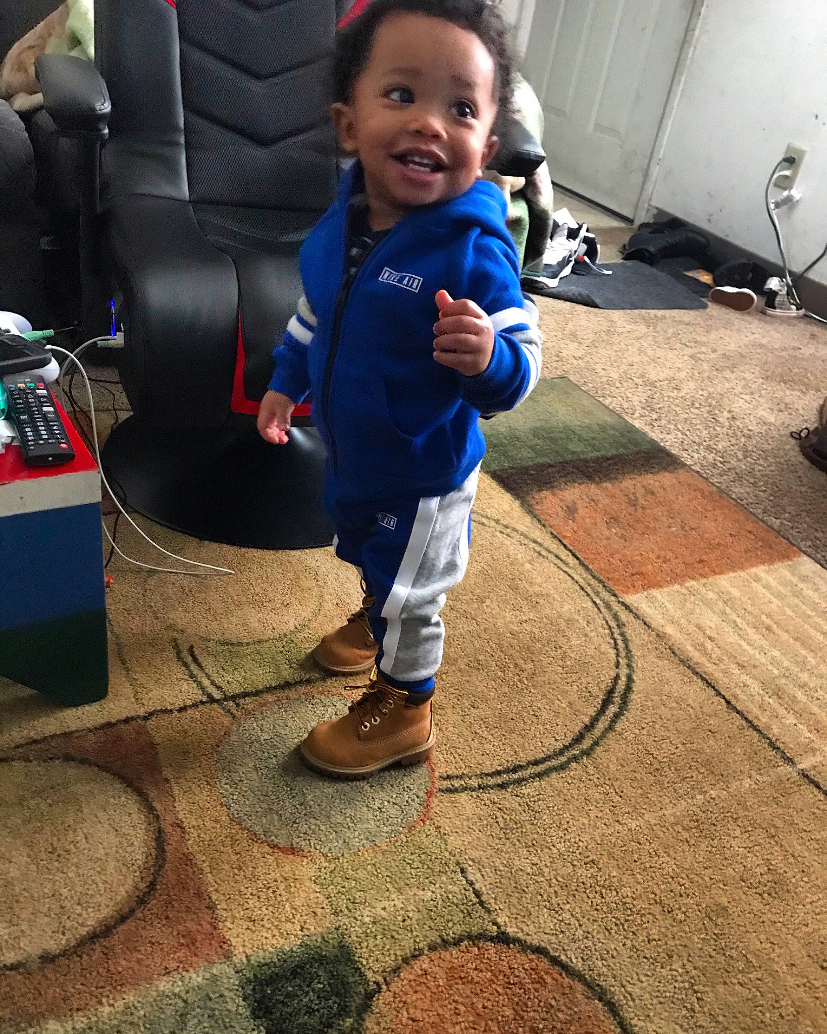 Alfred is registered to the contest to win money with this photo: ankle, baby, baby_toddler_clothing, child, flip_flops, floor, flooring, foot, joy, outdoor_shoe, person, play, sandal, shoe, slipper, sweatpant, toddler, walking_shoe