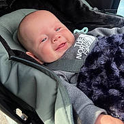 Lucas joined the competition — help win amazing prizes! baby, blanket, child, clothing, comfort, cozy, expression, face, fur, hand, hoodie, infant, outdoor, person, portrait, seat, smiling, stroller, warm, zipper