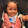 baby, child, smiling, curly_hair, car_seat, safety_harness, toy, pink_beads, daisy_duck, clothing, cute, portrait, infant, happy, indoors, person, closeup, expression, seat, accessory