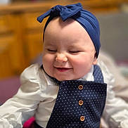 Nina participe au concours pour gagner de l'argent avec cette photo : baby, smiling, headband, blue, polka_dot, outfit, white_shirt, happy, cute, infant, portrait, indoor, child, clothing, button, face, person, soft_focus, blurry_background, joyful