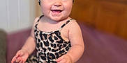 Nina a rejoint le concours — aidez-le/la à gagner de superbes lots ! baby, infant, smiling, sitting, leopard_print, headband, bow, clothing, indoor, portrait, child, happy, furniture, purple_bedspread, skin, cute, young_child, person, face, feet