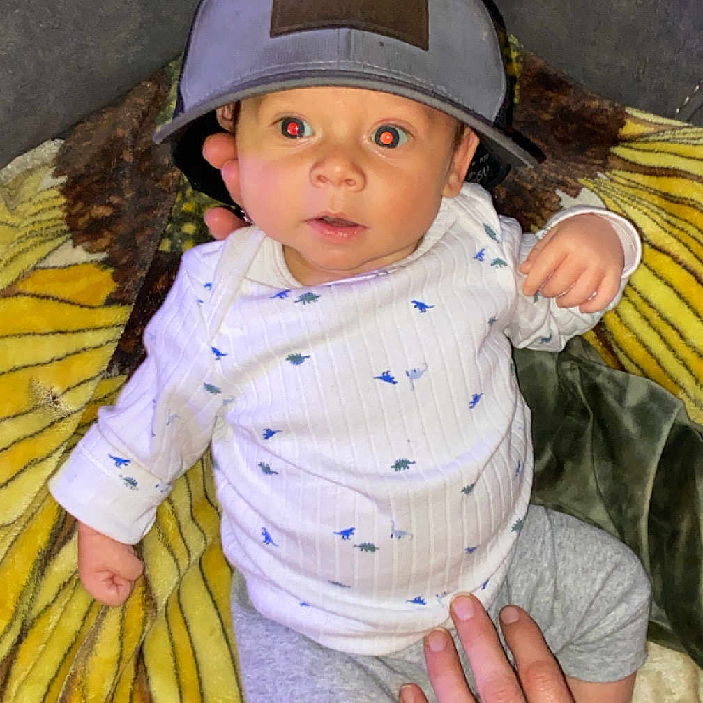 Rafe is registered to the contest to win money with this photo: accessories, baby, baseballcap, bodypart, cap, clothing, face, finger, furniture, hand, hat, head, helmet, jewelry, pants, people, person, photography, portrait, sunhat