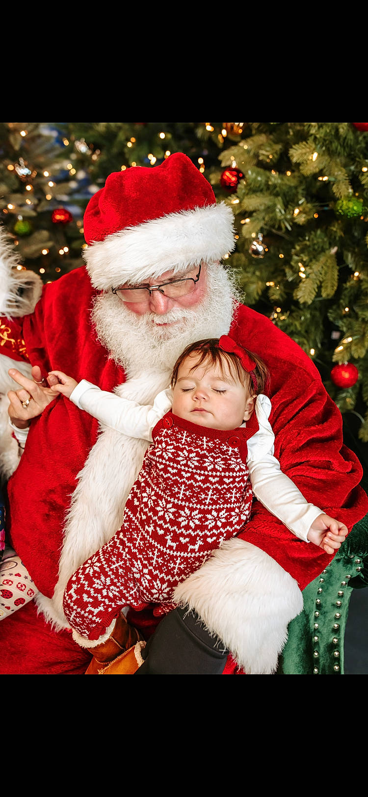 Adalynn is registered to the contest to win money with this photo: beard, christmas, christmas_decoration, christmas_eve, christmas_ornament, christmas_tree, event, facial_expression, fun, green, happy, hat, head, holiday, human_body, lap, person, red, santa_claus, standing