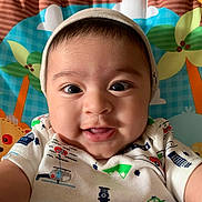 Liam joined the competition — help win amazing prizes! baby, child, smiling, face, hat, onesie, colorful, vehicle_prints, closeup, portrait, infant, happy, cute, indoors, playmat, background, cartoon_flowers, cartoon_animals, young_child, selfie