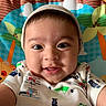baby, background, cartoon_animals, cartoon_flowers, child, closeup, colorful, cute, face, happy, hat, indoors, infant, onesie, playmat, portrait, selfie, smiling, vehicle_prints, young_child