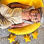 baby, infant, newborn, moon_pillow, yellow, stars, hat, glasses, suspenders, onesie, belly, hands, blanket, patterned_sheet, plush, cute, portrait, lying_down, cozy, nursery