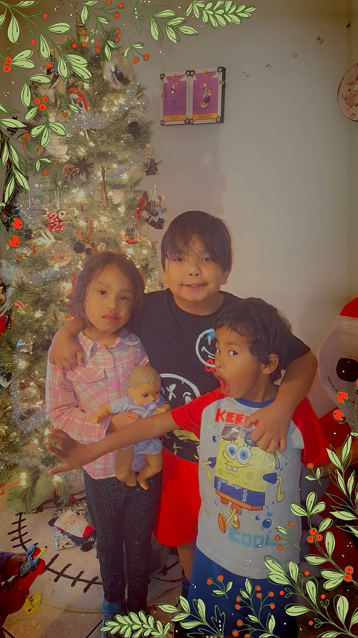 Maryane is registered to the contest to win money with this photo: beauty, child, christmas, christmas_decoration, christmas_ornament, christmas_tree, event, facial_expression, fun, happy, holiday, holiday_ornament, joy, leaf, ornament, person, photograph, room, smile, standing