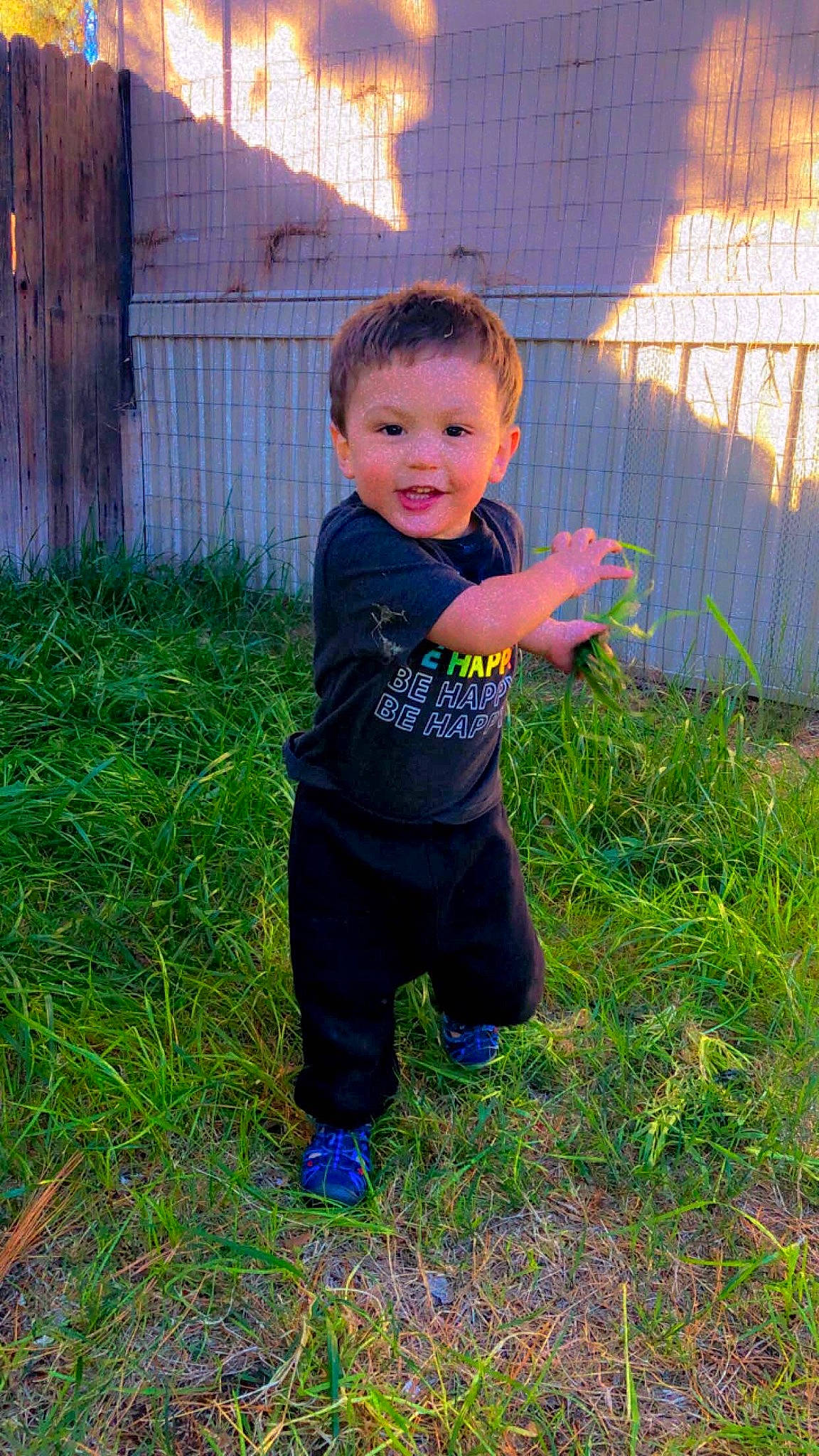 Jorden is registered to the contest to win money with this photo: baby, baby_toddler_clothing, child, electric_blue, fence, football, fun, grass, grass_family, grassland, happy, lawn, leisure, people_in_nature, person, personal_protective_equipment, plant, play, soil, t_shirt