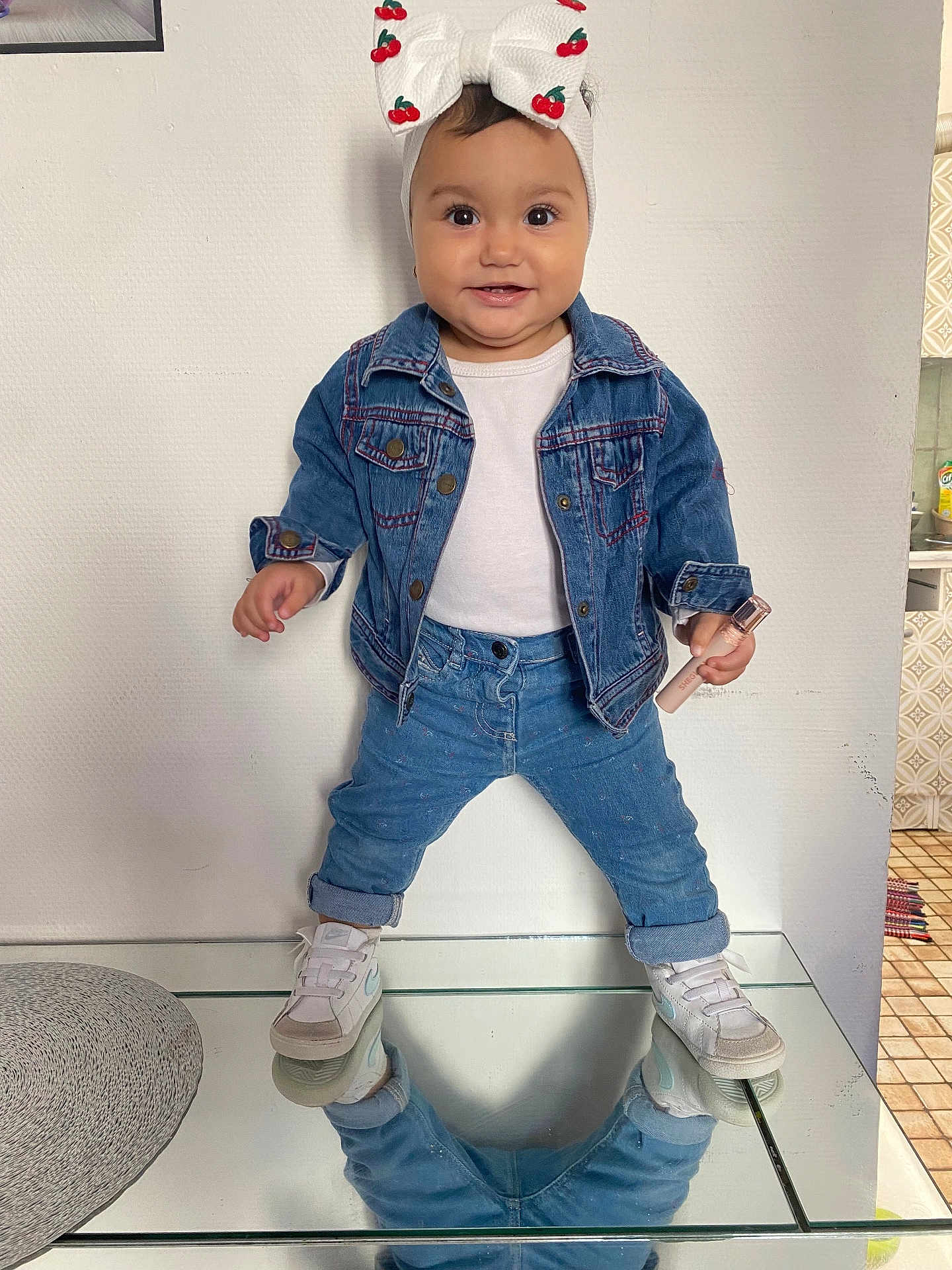 Medeea a rejoint le concours — aidez-le/la à gagner de superbes lots ! toddler, child, denim_jacket, jeans, white_shirt, headband, cherry_pattern, sneakers, glass_table, reflection, home_interior, kitchen, floor_tiles, smiling, posing, cosmetic_item, person, indoor, cute, fashion