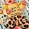 animal_print, baby, bed, child, crib, cute, elephant, happy, indoors, infant, jungle_theme, leaf_pattern, leopard_print, lion, monkey, person, playful, smiling, toddler, yellow_clothing