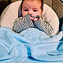 Easton joined the competition — help win amazing prizes! baby, infant, blanket, blue, striped_clothing, pacifier, cushion, soft_texture, face, hands, indoor, cute, child, newborn, young, portrait, resting, comfortable, warm, expression
