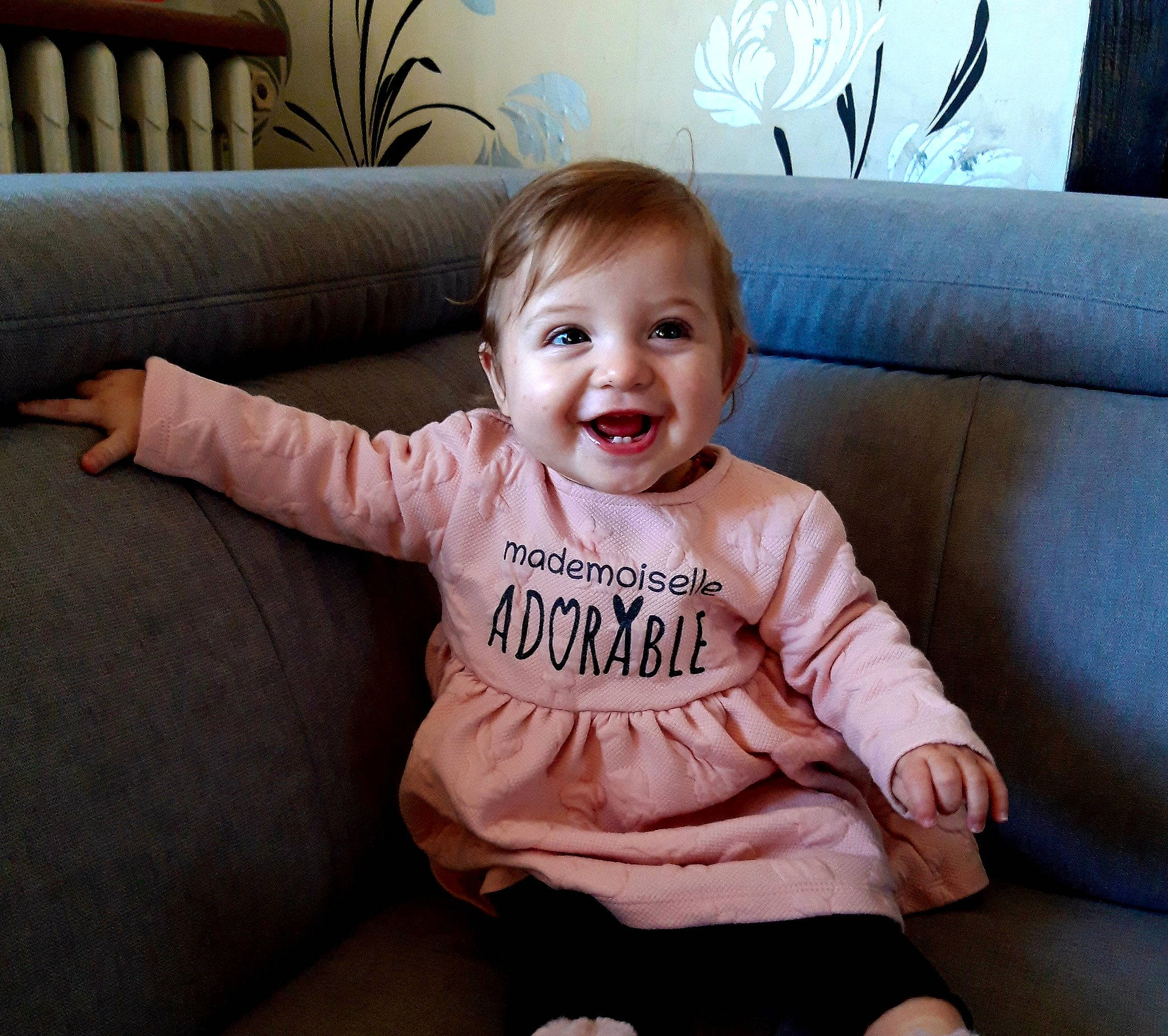 Victoria participe au concours pour gagner de l'argent avec cette photo : baby, baby_toddler_clothing, cheek, child, comfort, couch, eye, facial_expression, hairstyle, happy, head, iris, joy, living_room, person, sitting, skin, sleeve, smile, t_shirt