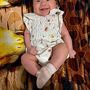 Jocelyn joined the competition — help win amazing prizes! baby, infant, smiling, white_clothing, floral_pattern, blanket, patterned_blanket, happy, cute, lying_down, face, tongue_out, child, skin, sock, small_hands, small_feet, indoors, portrait, joyful