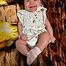 baby, infant, smiling, white_clothing, floral_pattern, blanket, patterned_blanket, happy, cute, lying_down, face, tongue_out, child, skin, sock, small_hands, small_feet, indoors, portrait, joyful