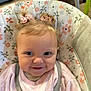baby, baby_seat, child, close_up, cute, face, floral_pattern, hair_bows, happy, indoors, infant, person, pink_clothing, portrait, seatbelt, small_hair_ties, smiling, soft_lighting, toddler, young_child