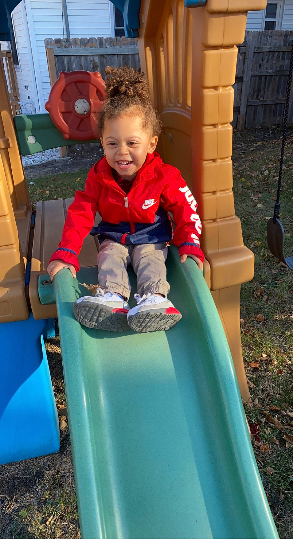 Mars is registered to the contest to win money with this photo: baby_toddler_clothing, blue, child, chute, city, electric_blue, fun, grass, happy, leisure, outdoor_play_equipment, person, plant, play, playground, playground_slide, recreation, sitting, smile, t_shirt