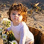 toddler, child, curly_hair, blue_eyes, white_clothing, wooden_bucket, daisies, flowers, outdoor, sand, sunlight, portrait, baby, nature, cute, innocent, garden, daylight, person, flower_arrangement