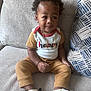 Symere is registered to the contest to win money with this photo: toddler, child, sitting, couch, clothing, shoes, chain, face, hair, cushion, indoor, portrait, happy, looking_away, fashion, footwear, casual, young_child, comfortable, expression