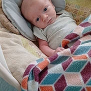 Wyatt joined the competition — help win amazing prizes! baby, blanket, clothing, colorful, comfort, cozy, cushion, expression, face, geometric_pattern, head, indoors, infant, pattern, portrait, resting, seat, skin, soft_texture, young_child