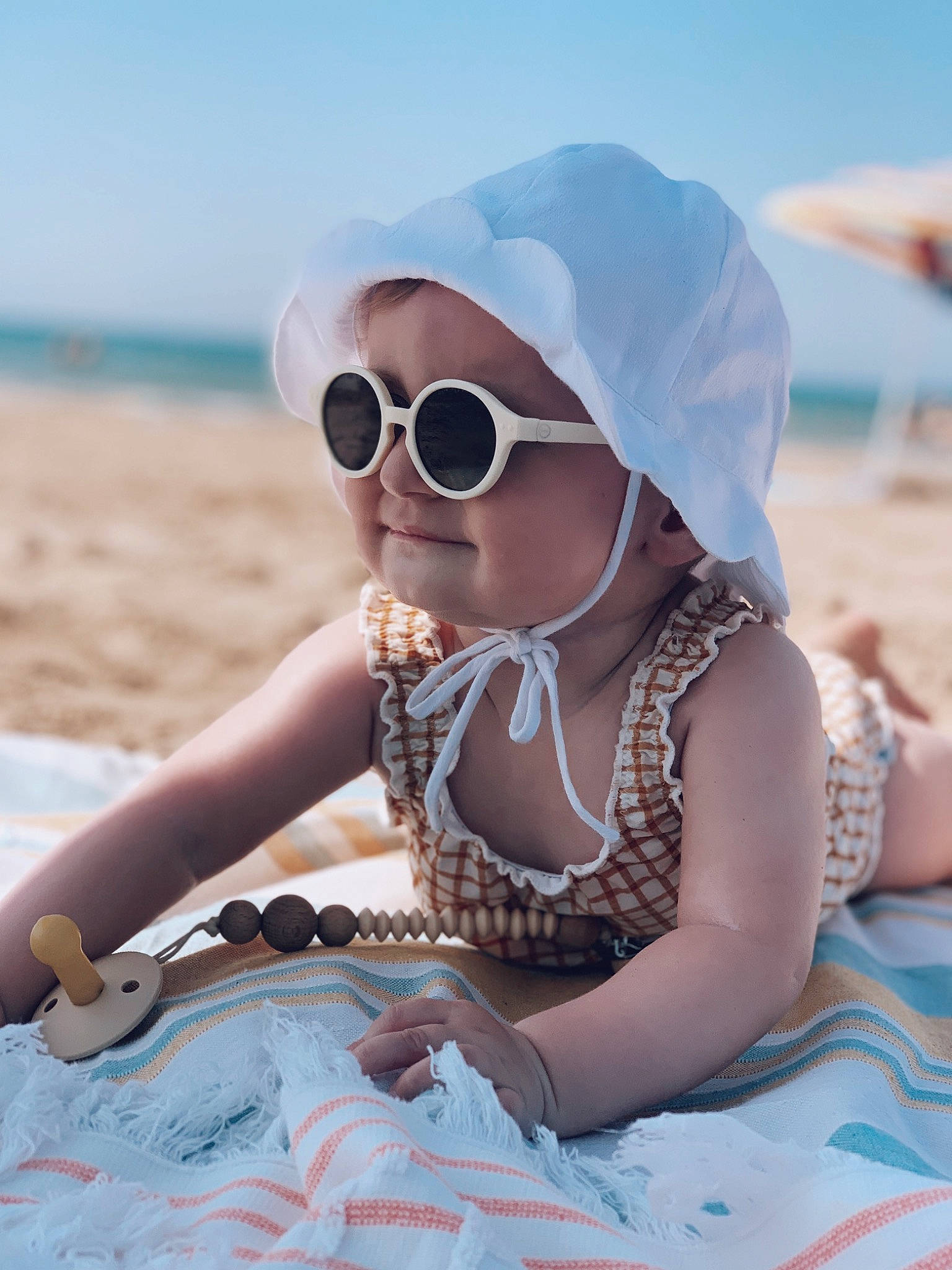Joséphine participe au concours pour gagner de l'argent avec cette photo : azure, beach, body_of_water, cool, eyewear, fun, glasses, goggles, happy, hat, headgear, headwear, landscape, leisure, people_on_beach, person, sand, sky, sunglasses, toddler