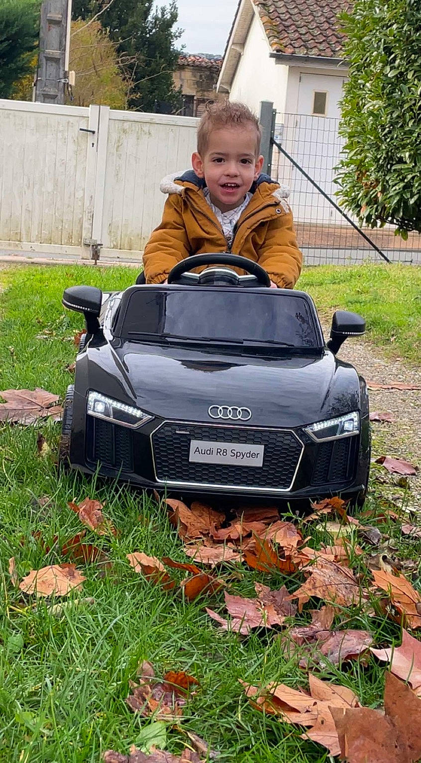 Lenzo participe au concours pour gagner de l'argent avec cette photo : automotive_design, automotive_exterior, automotive_lighting, automotive_tire, automotive_wheel_system, bumper, car, grass, grille, headlamp, hood, jacket, joy, motor_vehicle, person, personal_luxury_car, plant, rim, smile, vehicle
