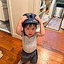 Kei a rejoint le concours — aidez-le/la à gagner de superbes lots ! toddler, child, helmet, indoor, wooden_floor, kitchen, person, shorts, socks, shirt, looking_up, hands_up, home, floor, cabinet, rug, appliances, curious, standing, casual_clothing
