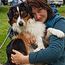 Tara participe au concours pour gagner de l'argent avec cette photo : woman, dog, hugging, outdoor, camping, grass, rv, trees, green_mug, table, smiling, casual_clothing, pet, leash, nature, daylight, portrait, friendly, happy, relaxed