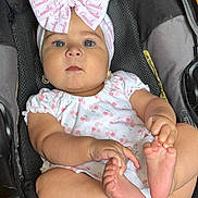 Camila joined the competition — help win amazing prizes! baby, infant, car_seat, headband, bow, cute, child, foot, hand, clothing, earrings, person, indoor, skin, expression, sitting, pink, white, pattern, floor