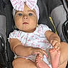 baby, infant, car_seat, headband, bow, cute, child, foot, hand, clothing, earrings, person, indoor, skin, expression, sitting, pink, white, pattern, floor