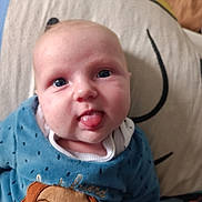 Louis participe au concours pour gagner de l'argent avec cette photo : baby, blue_clothing, child, closeup, cute, dog_design, expression, face, head, indoors, infant, person, pillow, playful, portrait, skin, smiling, soft_texture, tongue_out, young