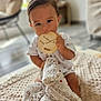 baby, blanket, blurred_background, child, comfort, cute, face, feet, floor, hands, home, indoor, infant, milestone_marker, nibbling, plush_toy, short_sleeve, sitting, soft_toy, wooden_milestone