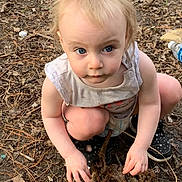 Lily is registered to the contest to win money with this photo: baby, blond_hair, blue_eyes, branches, casual_clothing, child, crouching, curious, forest, ground, leaves, nature, outdoors, pine_needles, portrait, sitting, sneakers, toddler, twigs, woodland