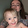 Lily joined the competition — help win amazing prizes! adult, bare_shoulders, blonde_hair, brown_hair, child, closeup, face, family, floral_clothing, glasses, happy, home, indoor, photography, portrait, selfie, shoulders, smiling, toddler, woman
