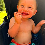 Eziah is registered to the contest to win money with this photo: toddler, child, smiling, outdoor, sunlight, stroller, happy, baby, face, skin, hand, shorts, clothing, summer, nature, greenery, seatbelt, playful, portrait, cute